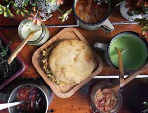 Arepa venezolana rellena servida con salsas tradicionales
